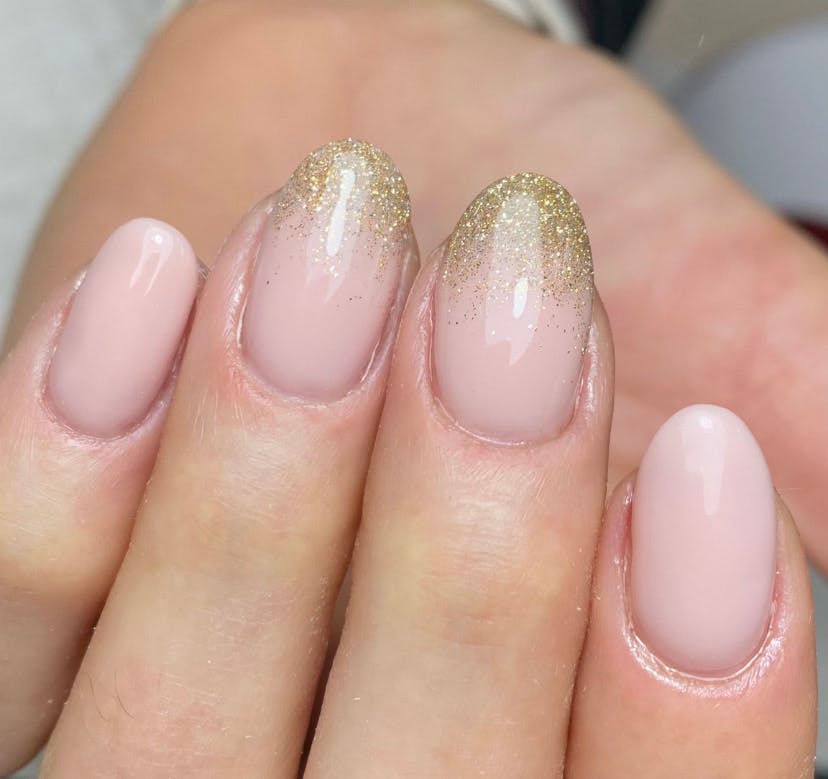 Nude/Pink nails with sparkly, golden French tips