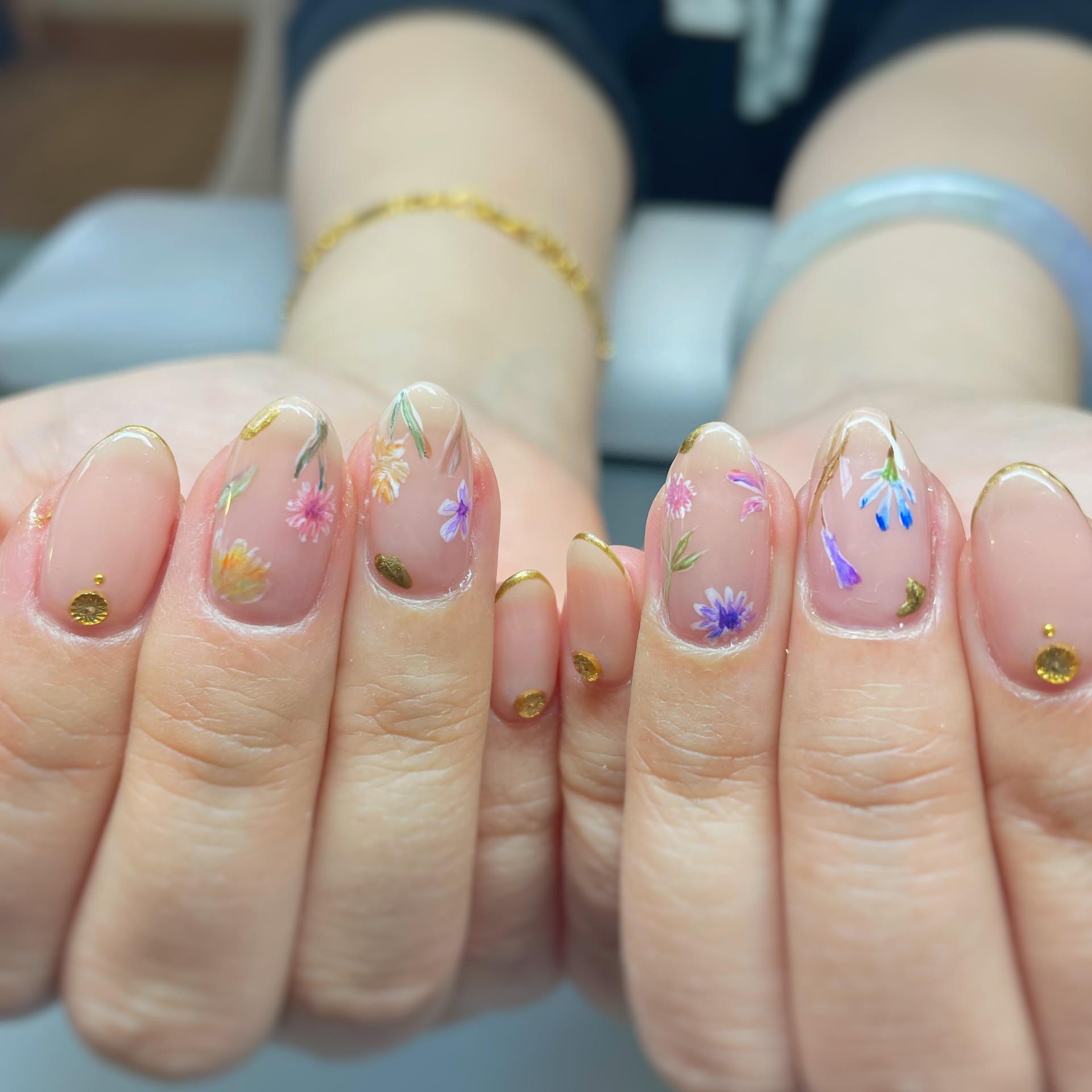 Floral nails with gold French tips and gold flower gems